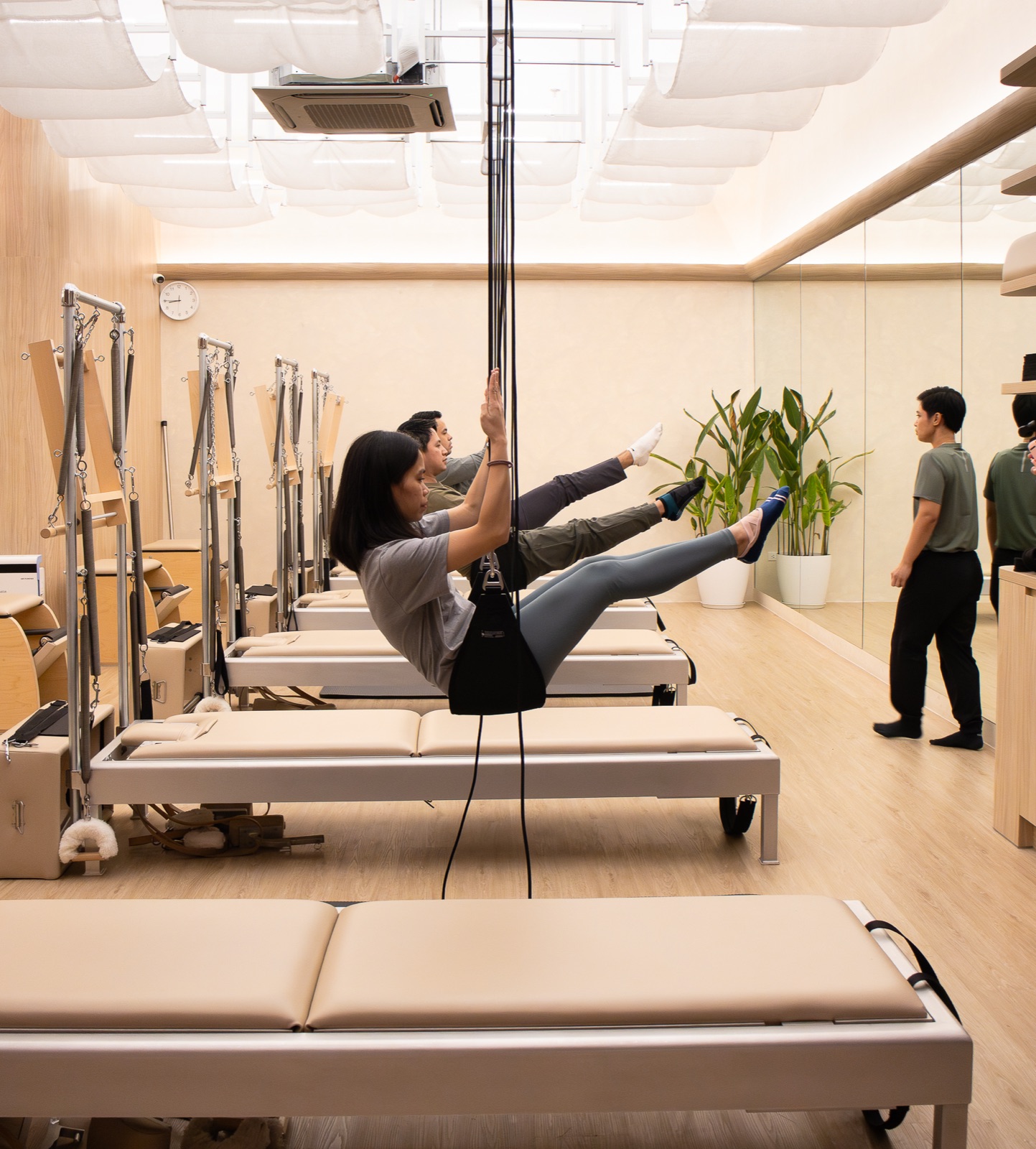 Reformer work in the warm, mirrored studio room